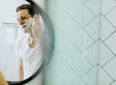 man shaving in front of mirror